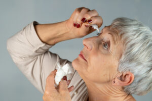 Woman putting in eye drops