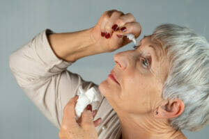 woman using eye drops