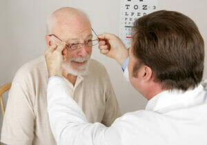 eye doctor putting glasses on patient 